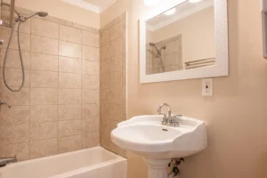 A bathroom with a sink, bathtub and mirror.