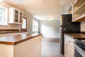 A kitchen with white cabinets and black counter tops.