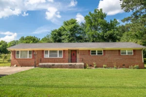 A house with grass and trees in the background.