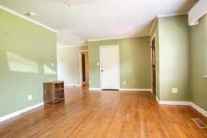 A room with hard wood floors and green walls.