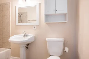 A bathroom with a sink, mirror and toilet.