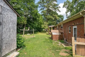 A yard with trees and grass in the background