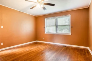 A room with wood floors and an open window.