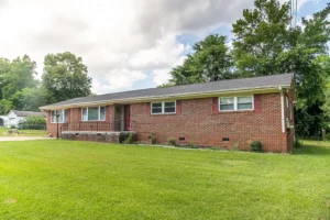 A brick house with grass in front of it.