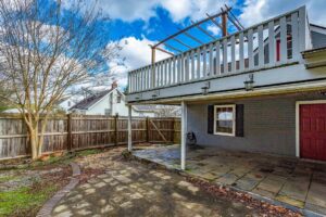 A patio with a deck and pergola in the back yard.