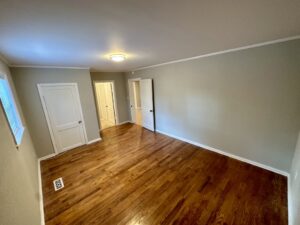 A room with wood floors and white walls.