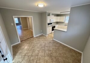 A kitchen with tile floors and white walls.