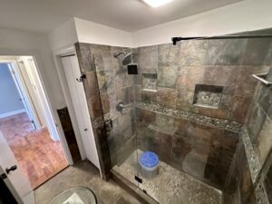 A bathroom with a walk in shower and tiled walls.