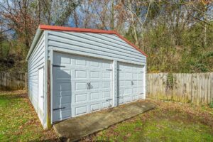 A white garage with two doors and red roof.