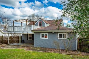 A house with a porch and a deck in the back yard.