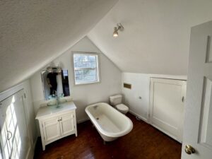 A bathroom with a tub, sink and mirror.