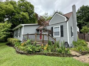 A house with flowers growing in front of it.