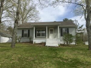 A house with a porch and steps in front of it.