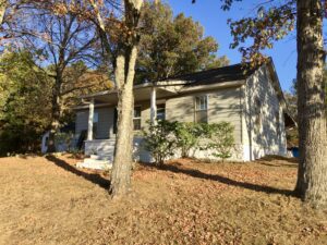 A house with trees and leaves on the ground