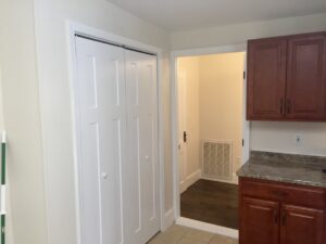 A white door and some brown cabinets in a room.