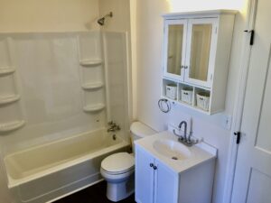 A bathroom with white fixtures and a toilet.