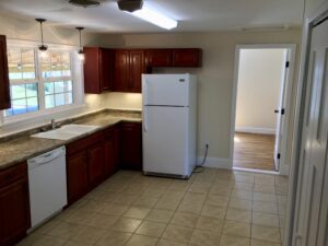 A kitchen with white appliances and brown cabinets.