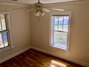 A room with a ceiling fan and window.