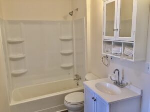 A bathroom with white fixtures and a toilet.