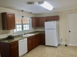 A kitchen with brown cabinets and white appliances.