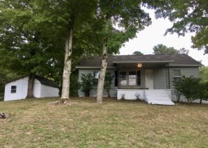 A house with trees and grass in front of it