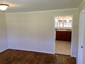 A room with white walls and wooden floors.