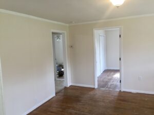 A room with hard wood floors and white walls.