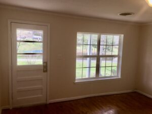 A room with two windows and a door.