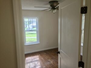 A room with a ceiling fan and a window.