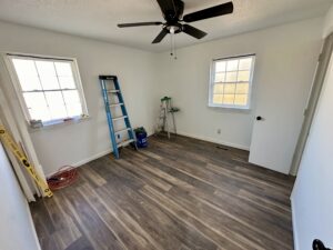 a bedroom with two ladders and a fan