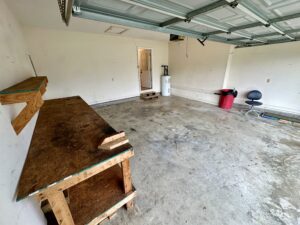 Empty garage with a workbench and chair.