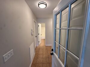 White door with glass panels in hallway.