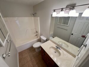 White bathroom with shower and sink.