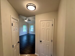 Hallway with closed doors and hardwood floor.