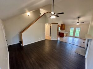 Open living room with stairs and fireplace.