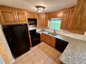 Kitchen with black appliances and granite counters.