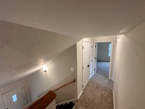 Hallway with carpeted floor and two doors.