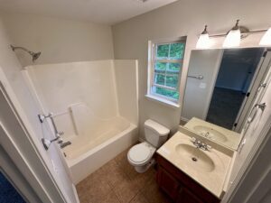 White bathroom with tub, sink, and toilet.