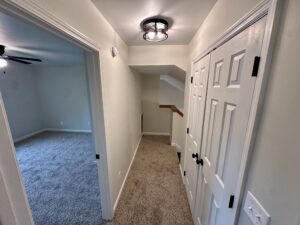 White doors in a carpeted hallway.