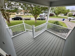 Front porch with white railings and grey deck.