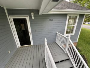 Front porch with white railing and steps.