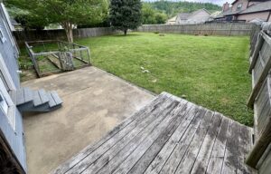 Backyard with wooden deck and steps.