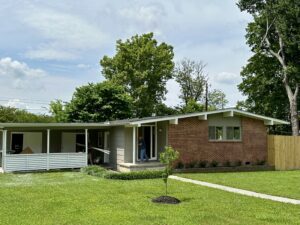 Brick ranch house with green lawn.