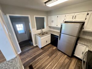 Kitchen with stainless steel refrigerator and white cabinets.