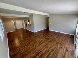 Empty room with hardwood floors and white trim.