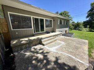 Concrete patio with steps and house.