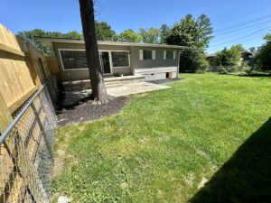 Backyard with green grass and fence.