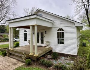 White house with porch and columns.