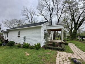 White house with porch and walkway.