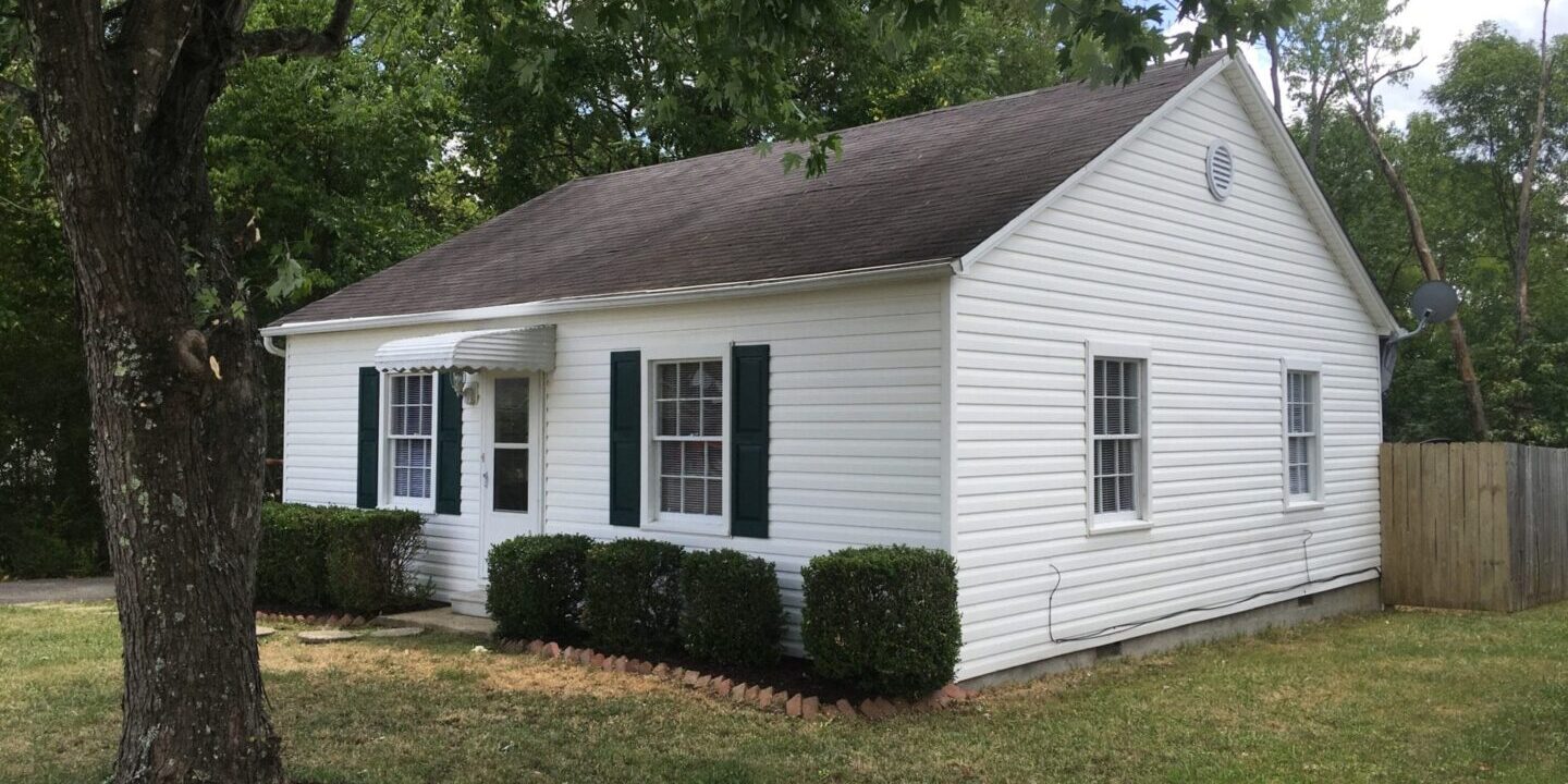Cozy white bungalow with green shutters